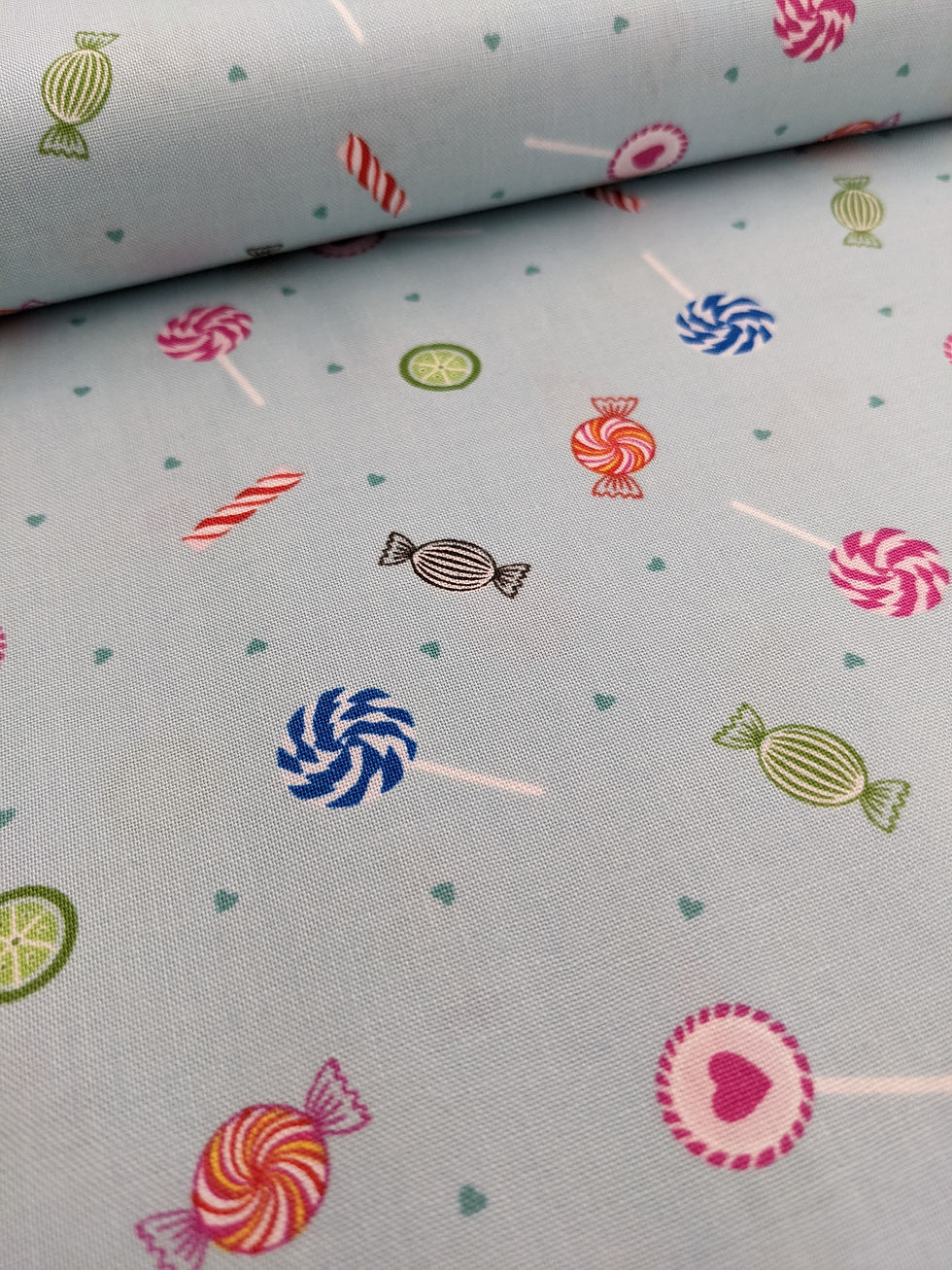 Thumbnail: Light blue fabric with candy and lollipop pattern, suitable for crafting projects.