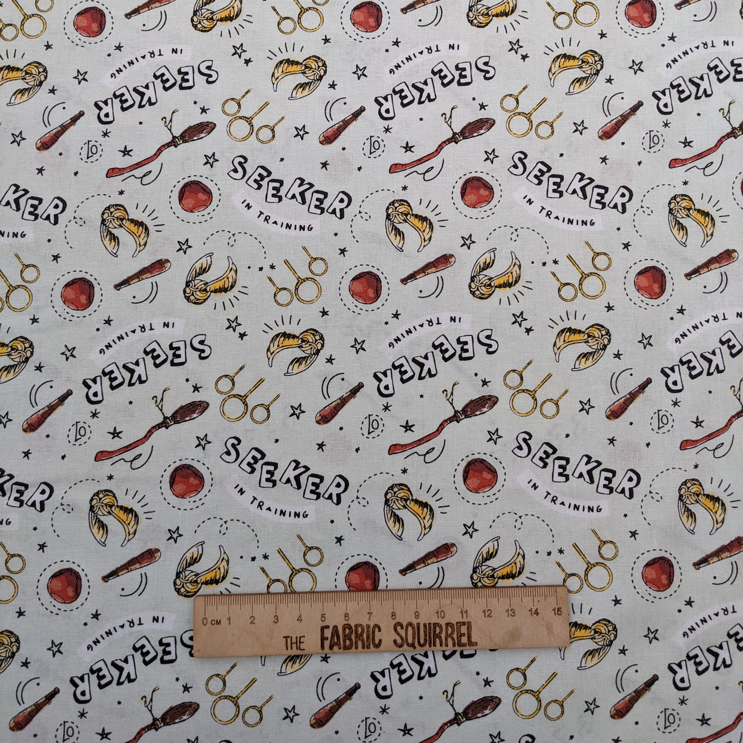 White fabric with scissors, text, and hair: The Fabric Squirrel pattern design.