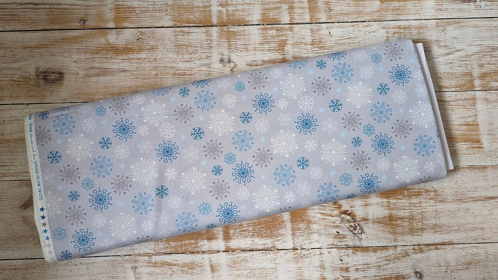 Thumbnail: Light blue fabric with snowflakes design on wooden surface background.