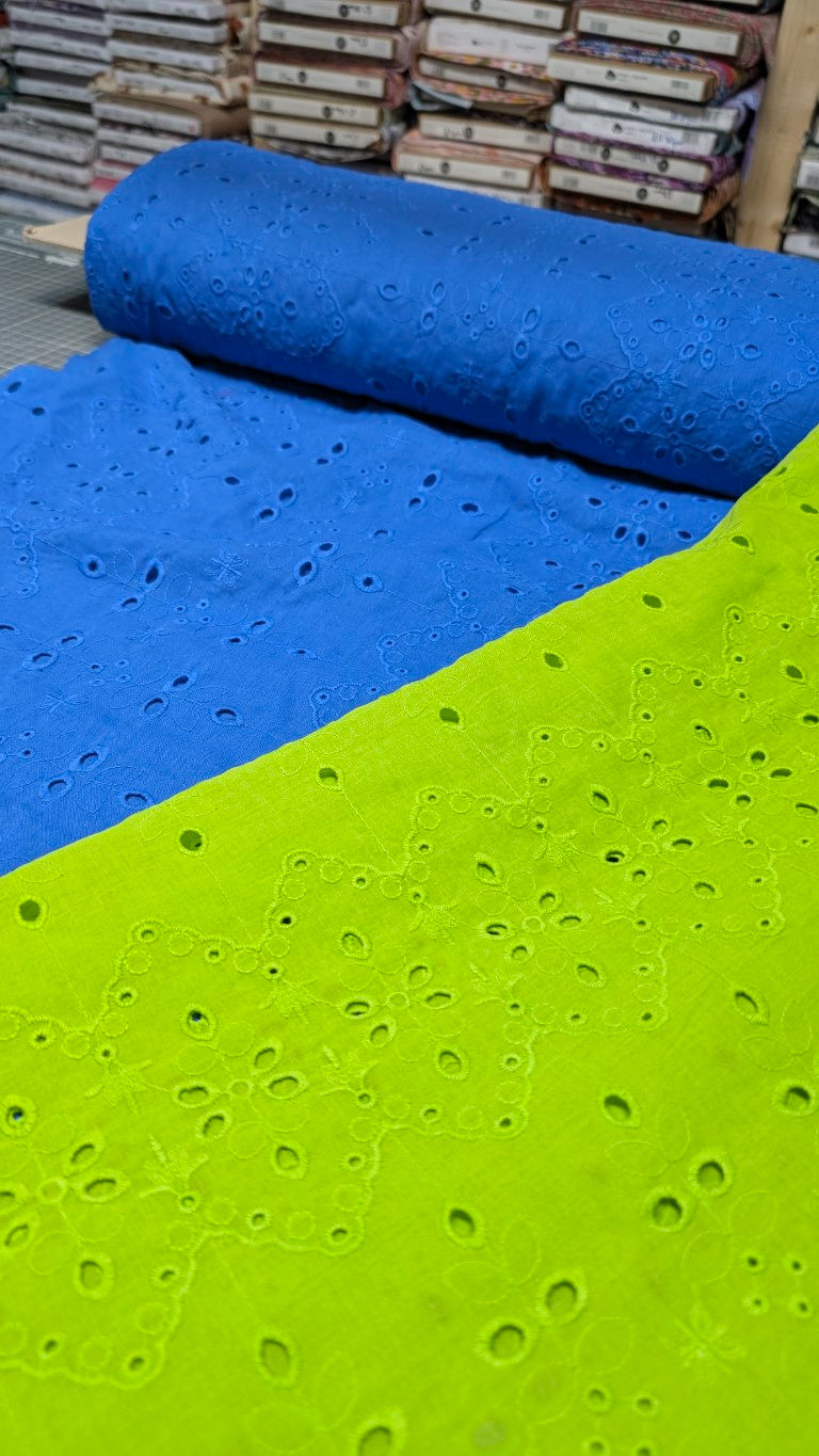 Thumbnail: Bright blue and lime green fabric with small holes in close-up shot.