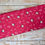 Thumbnail: Red fabric with white floral and bird pattern on wooden surface background.
