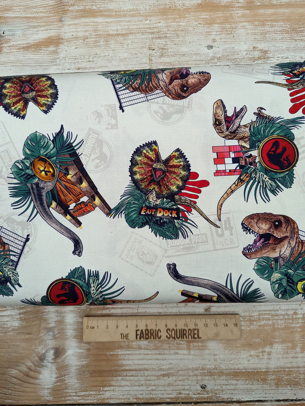 Thumbnail: Dinosaur fabric with red, green and brown images, The Fabric Squirrel.
