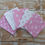 Thumbnail: Pink and white patterned fabric squares on wooden table, Fabric Squirrel logo.