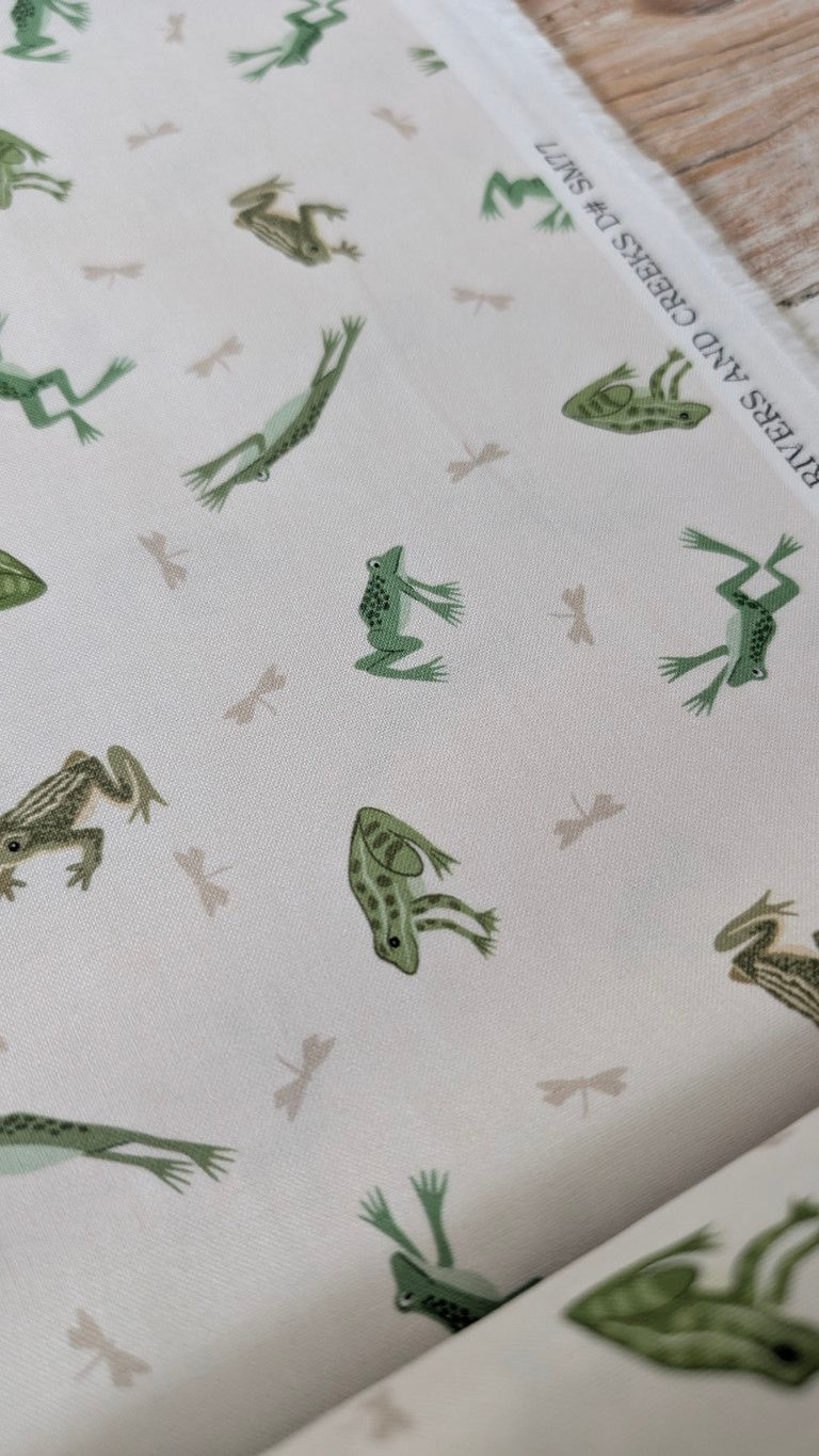 Green frogs and bones pattern on white fabric, Rivers and Co label visible.