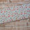 Thumbnail: Floral fabric roll: pink, blue, red flowers; The Fabric Squirrel on wooden surface.