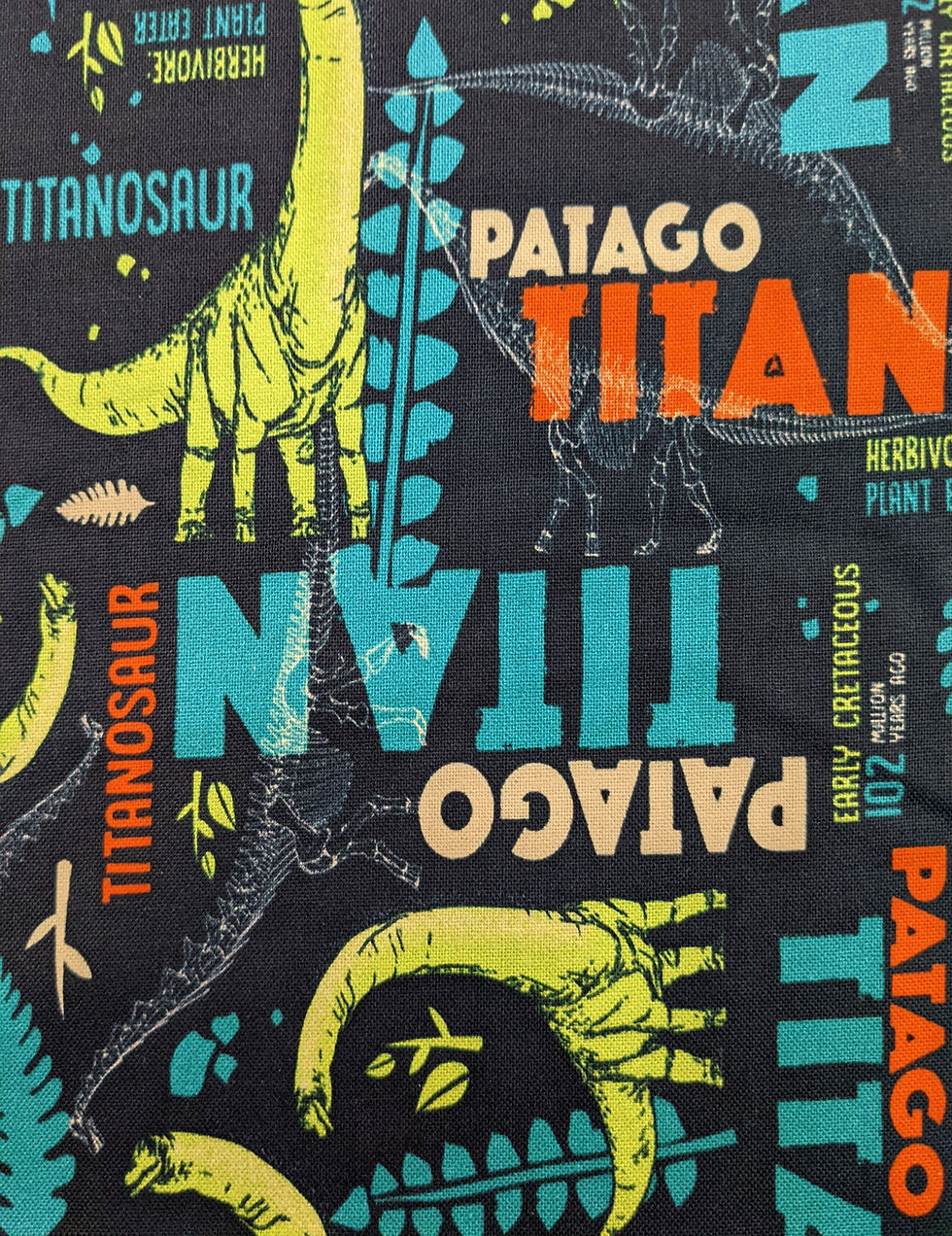 Fabric with Titanosaur text and dinosaur illustration, black background.