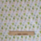 Fabric with green figures, rainbows, and the text THE FABRIC SQUIRREL on white background.