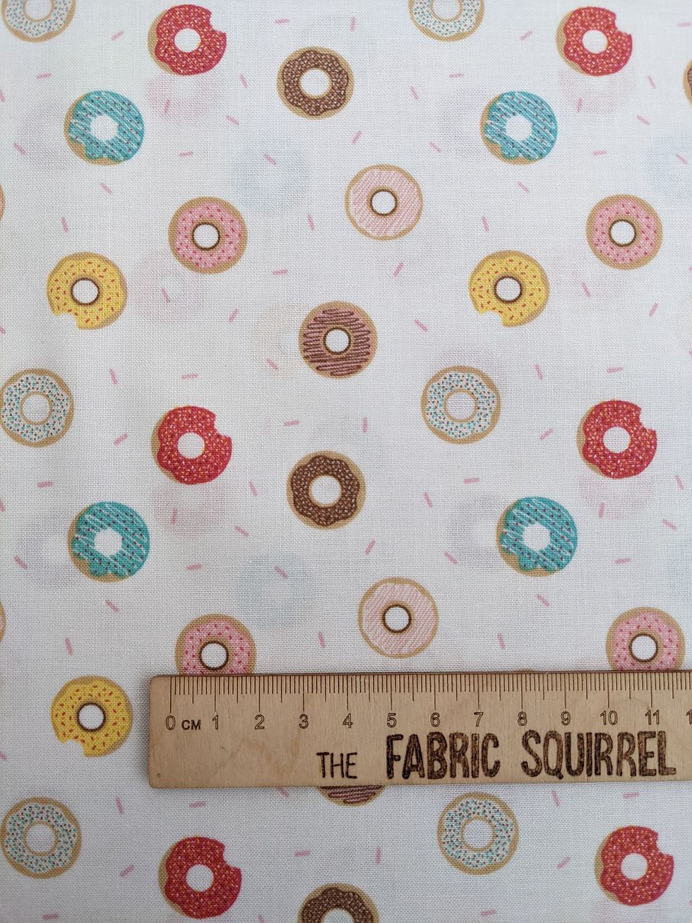 Thumbnail: Fabric with colorful donuts pattern and ruler, The Fabric Squirrel product.