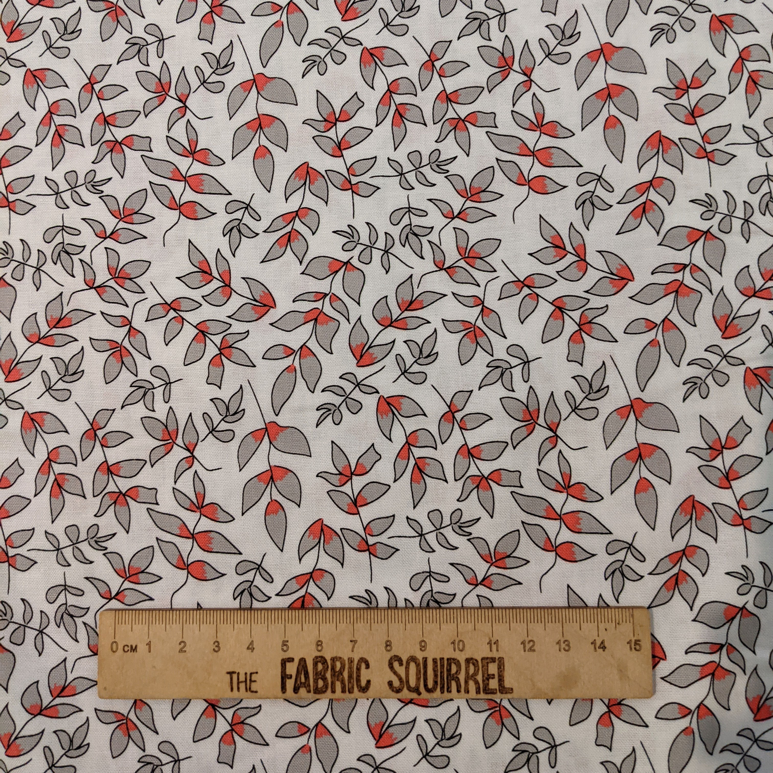 Fabric with red and gray leaves, text, and measuring tape. The Fabric Squirrel.