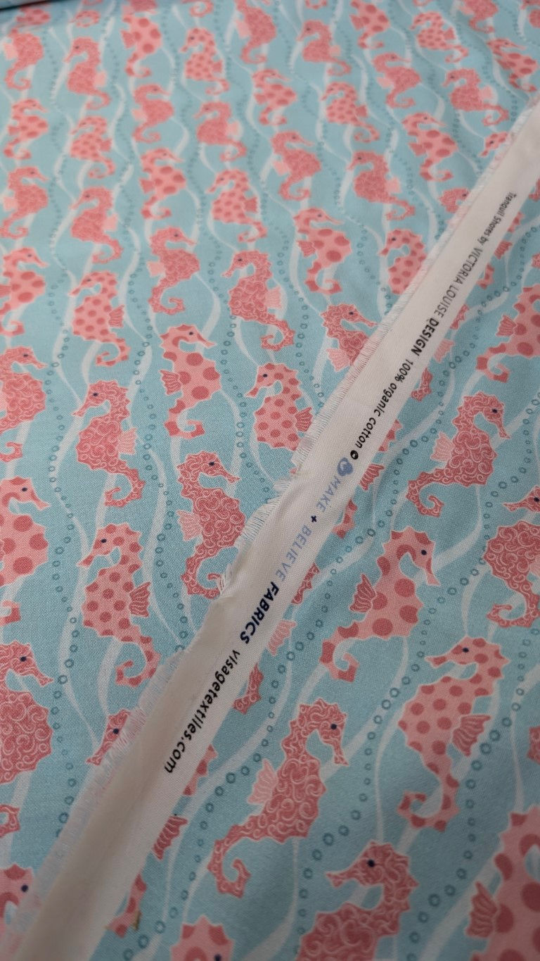 Thumbnail: Fabric with seahorse pattern and white tag. The Fabric Squirrel branding.