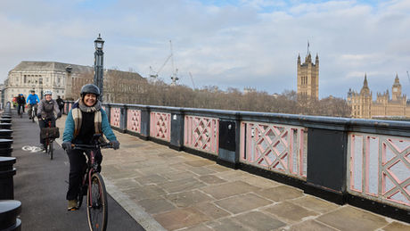 Hajera riding her bike over Lambeth Bridge, London