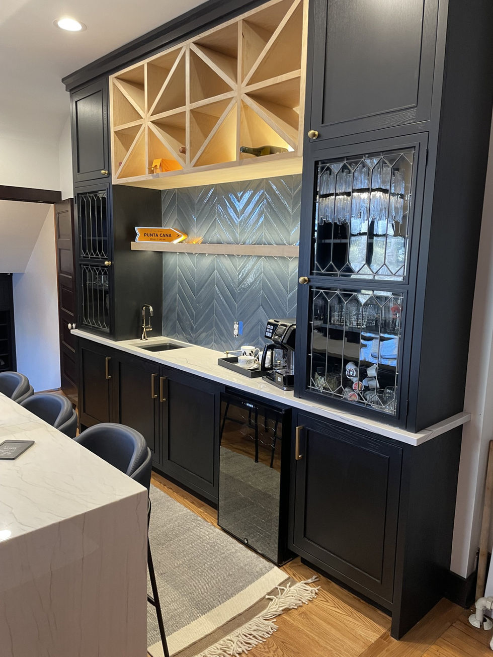 Photo of dry bar with reclaimed leaded glass cabinet fronts from original kitchen.