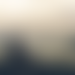 A woman resting on a hillside looking out at the view, with sunlight rays coming through the clouds