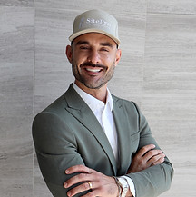 Smiling man in suit, arms crossed