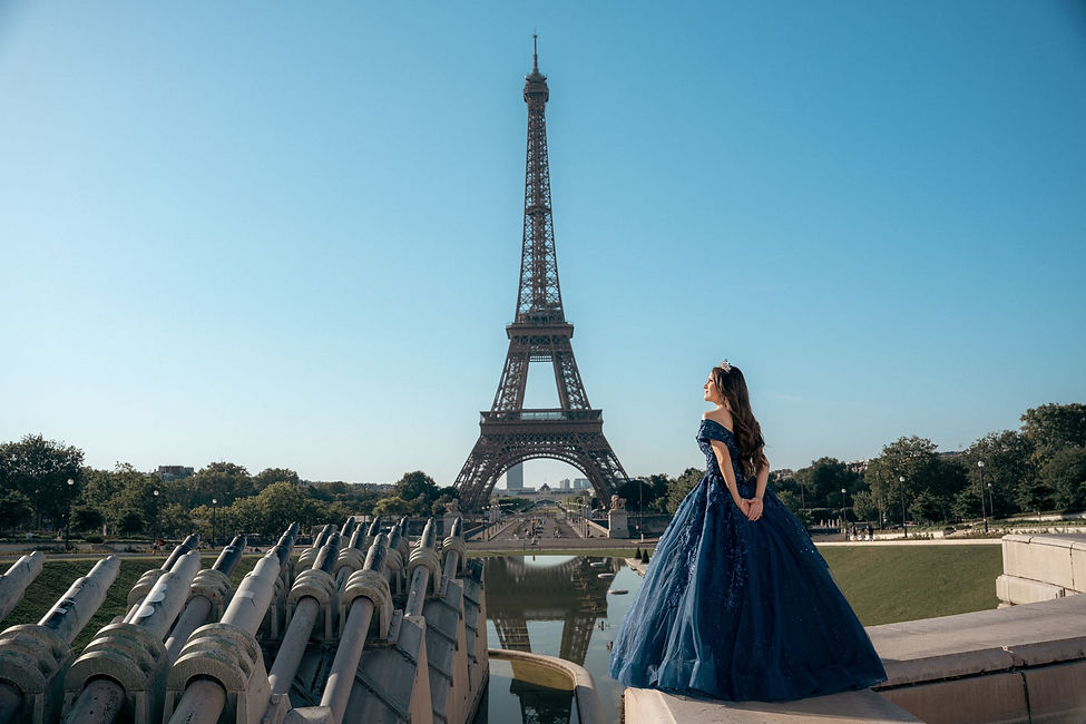 Quinceañera con vestido azul y tiara frente a la Torre Eiffel en París