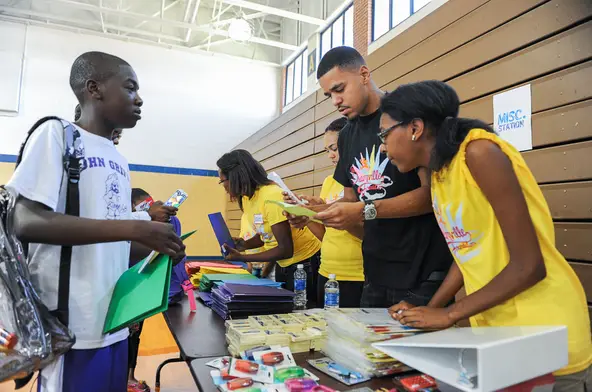 Rapper J. Cole helps give school supplies to John Griffin Middle School student for his back-to-school giveaway held through J. Cole's Dreamville Foundation.