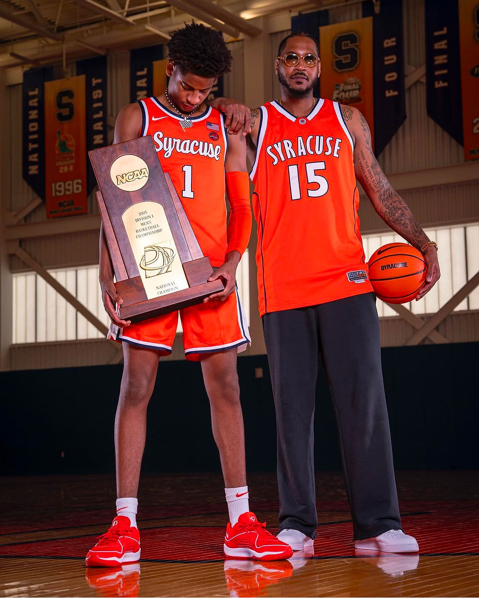 Kiyan Anthony stands with father Carmelo Anthony, holding his 2003 trophy