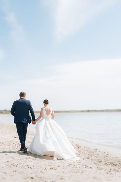 portrait de mariés couple sur plage en Bretagne robe blanche et costume foncé