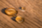 Three water beads on finished oak wood. Horizontal image..jpg