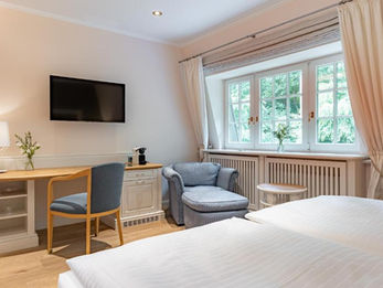 Cozy hotel room with a desk, chair, and large window view. 