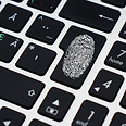 Close up of a keyboard Enter key with a white fingerprint painted on top