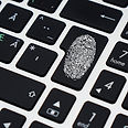 Close up of a keyboard Enter key with a white fingerprint painted on top
