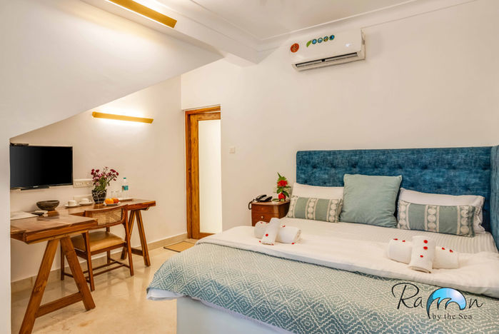 King bed with blue headboard and white walls in the Garden Room
