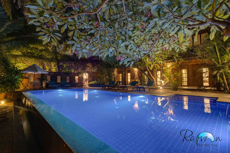 Infinity pool lit up at night with tree reflections.