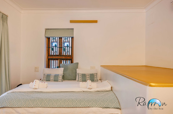 Cozy bed near traditional shutter window.