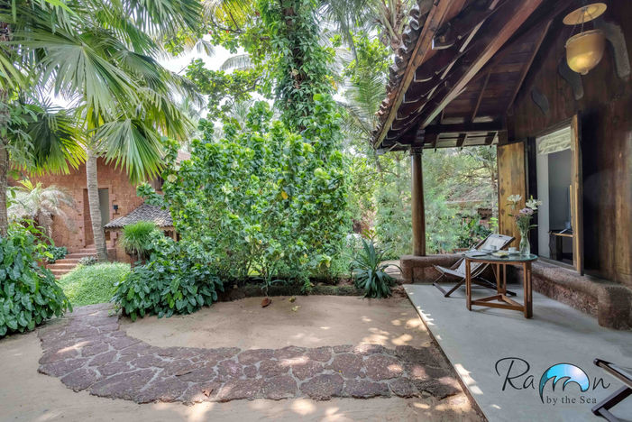 Relaxed outdoor patio with chairs surrounded by thick greenery
