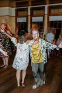 Two guests on the dance floor with their arms out stretched.