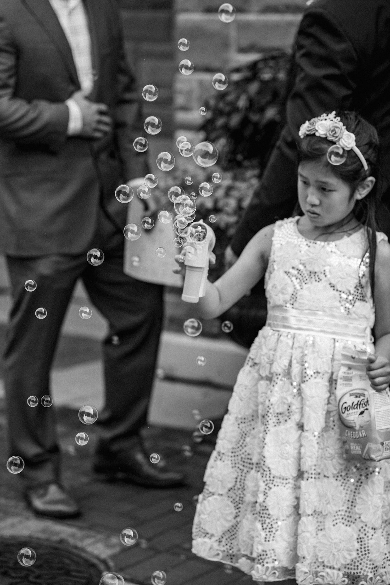A little girl blows bubbles during a break between ceremony and reception.