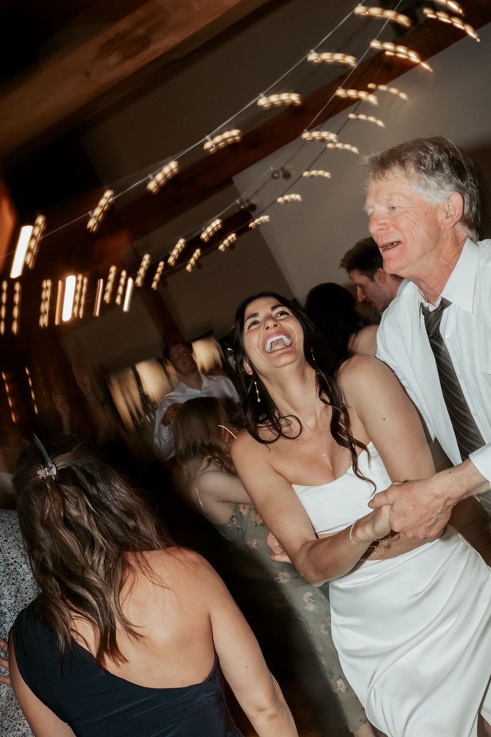 bride, groom and wedding guests dancing