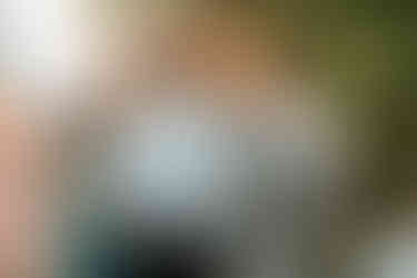 A guest has his hand on the grroms shoulder as they share a moment surrounded by guests.