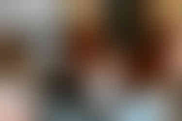 A little girl waves her hand and a ribbon in the air.