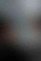 The bride and groom gaze into each other eyes, framed by guests.