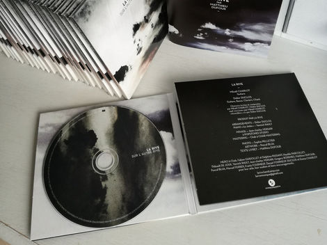 cd du groupe la rive qui s'appelle sur l'autre rive et aperçu du livret dans lequel on retrouve une nouvelle écrite par Matthieu Dufour