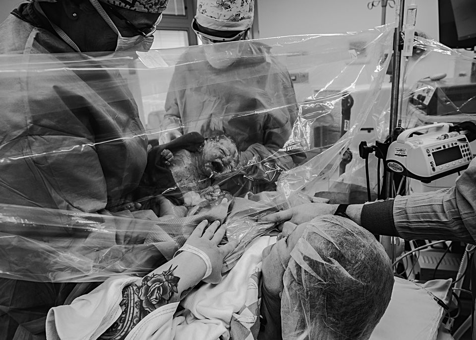 Newborn baby Birth photography in Portland, Maine - Birth Photography in hospital Mom looking through C-Section curtain