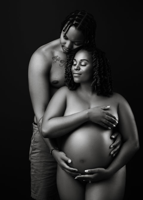 Studio Maternity Photography Portfolio in Falmouth, Maine with photo of a pregnant woman posing in with man hugging her