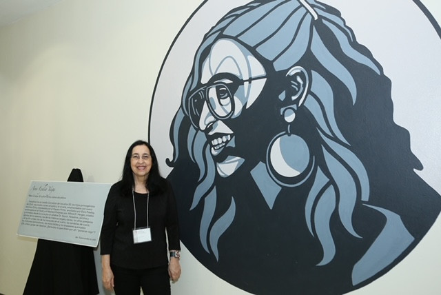 La escritora puertorriqueña Ana Lydia Vega junto al mural realizado en su honor. Foto: Suministrada