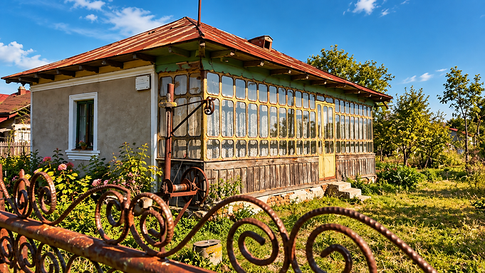 Sunlit Cottage Behind Rustic Ironwork.png