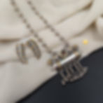 Designer two tone necklace set featuring an intricately carved centerpiece and dangle earrings.