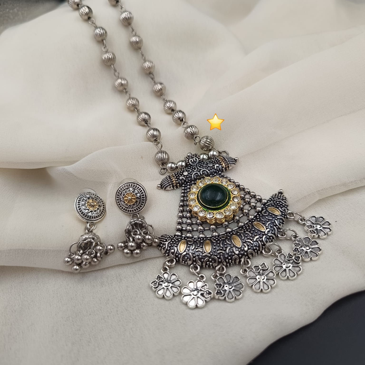 Handmade ethnic jewelry set displaying an oxidized metal statement pendant paired with matching dangle earrings.