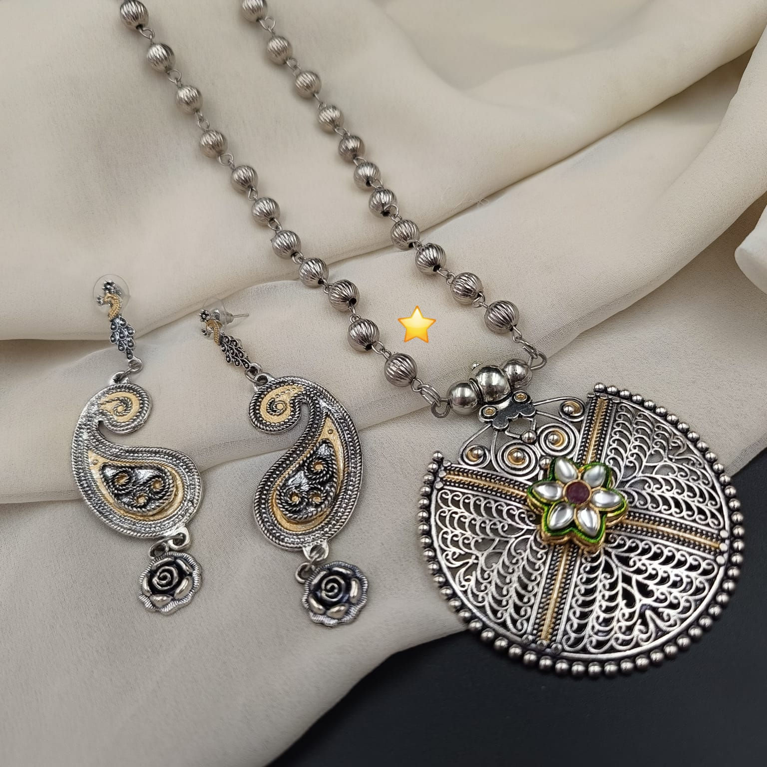 Handcrafted beaded two tone necklace set displaying an antique oxidized focal pendant paired with drop earrings.