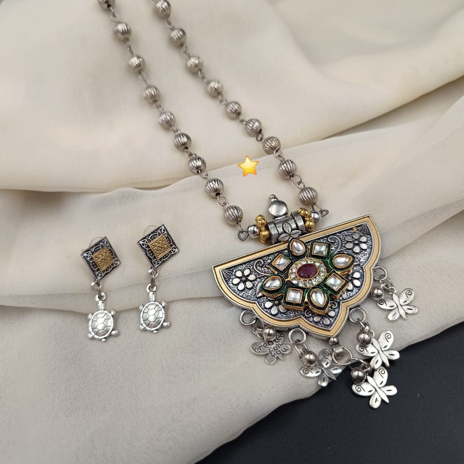 Vintage Afghan necklace set displaying an antique oxidized metal statement pendant and matching statement earrings.