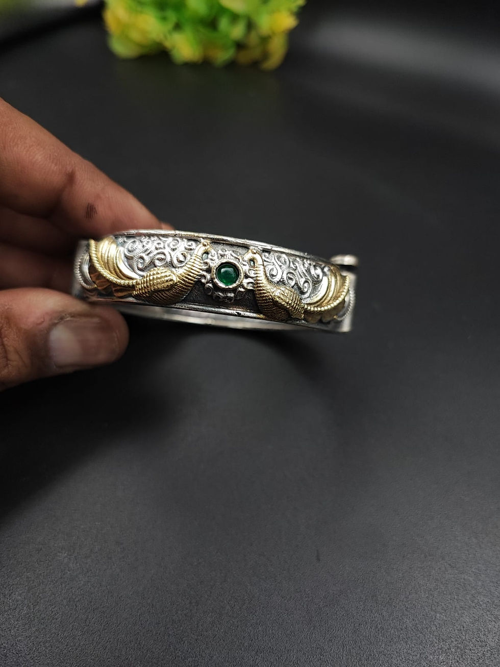 Dual tone oxidised brass peacock kada bangle with gold wing motif and gemstone centre, handcrafted Indian jewellery