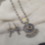 Traditional dual tone necklace set with an intricately carved centerpiece and statement dangle earrings