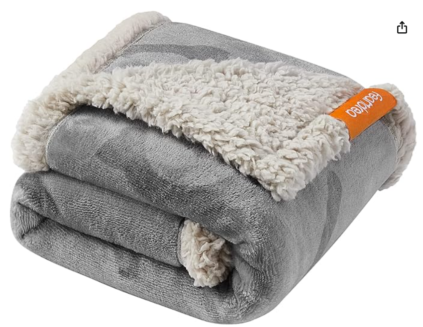 Folded gray dog blanket with white sherpa lining