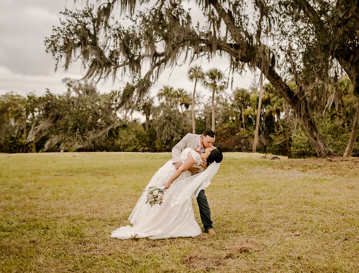 Bride and groom share a romantic kiss on their wedding day at The Celebration Barn, a rustic wedding venue in Florida