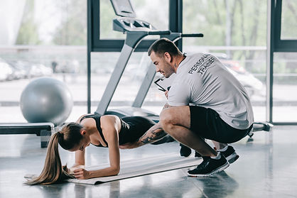 stock-photo-male-personal-trainer-helping-young-athletic-woman-doing-plank-fitness.jpeg